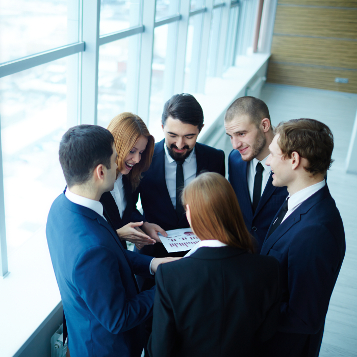 Group of business partners discussing paper at meeting in office